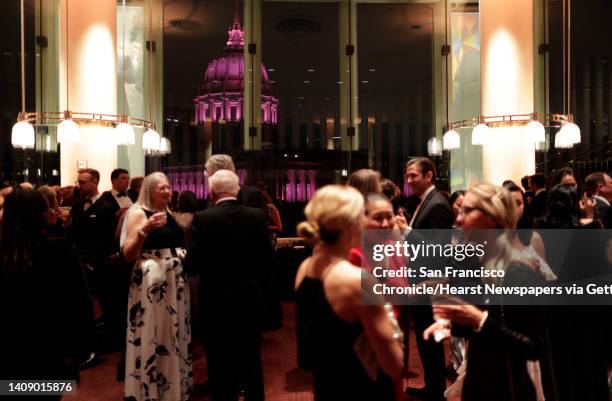 San Francisco City Hall bathed in pink as guests chat during intermisison at Davies Symphony Hall in San Francisco, Calif., on Wednesday, September...