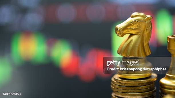money with chess,gold unicorn chess and business chart ,business concept - cost management stockfoto's en -beelden