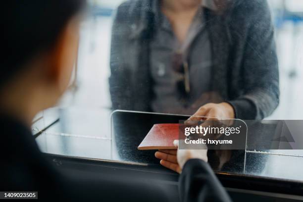 passenger checking in at airline counter - paspoort stockfoto's en -beelden