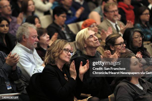 Audience members applaud during a public forum to address how San Francisco can provide lawyers to help immigrants fight deportation and how the...