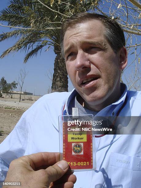 Anchor Brian Williams of "NBC Nightly News with Brian Williams" wears a "Temp Worker, Escort Required" credential for a report from Baghdad on March...