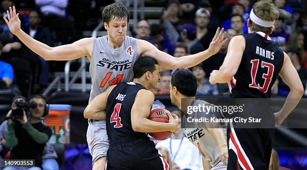 Texas Tech's Ty Nurse draws a charging foul after driving into Oklahoma State's Marek Soucek during the first half of a Big 12 Tournament game at the...