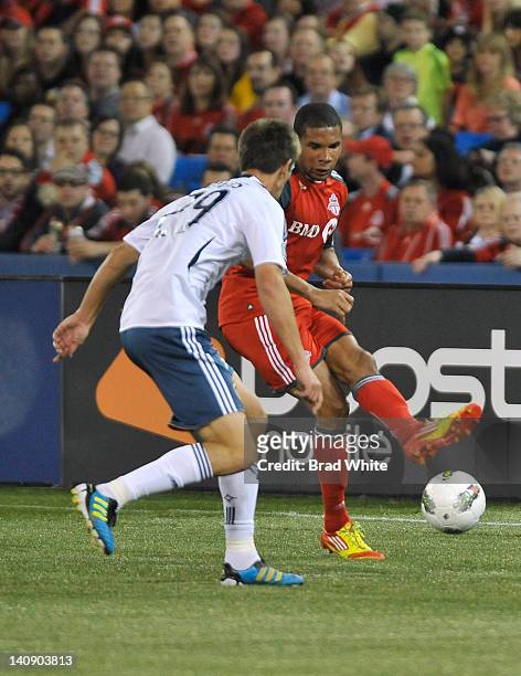 Ryan Johnson of the Toronto FC looks to pass the ball as Andrew Boyens of the Los Angeles Galaxy defends during CONCACAF Champions League game action...