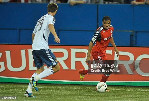 Ryan Johnson of the Toronto FC looks to pass the ball as Andrew Boyens of the Los Angeles Galaxy defends during CONCACAF Champions League game action...