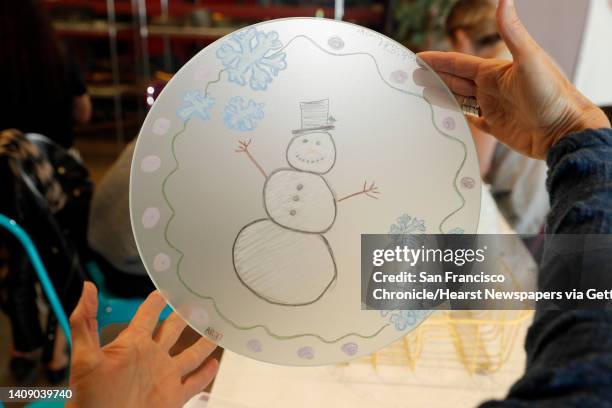 Annie Morhauser holds a plate drawn by Adriana Rodoni in her "Make-A-Plate" Workshop at Annieglass in Watsonville, Calif., Sunday, November 12, 2017....