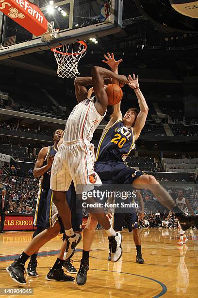 Gordon Hayward of the Utah Jazz on the block against Bismack Biyombo of the Charlotte Bobcats during the game at the Time Warner Cable Arena on March...