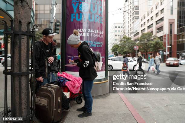 Seth Johnson and his girlfriend Amber Fina, who were abandoned by travel companions in the city five months ago, look for a place to panhandle on...