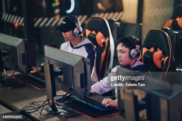 asian chinese esports team gamer focus playing rpg first shooter game in grand final sport event championship arena. cyber games tournament event - finals game two stockfoto's en -beelden