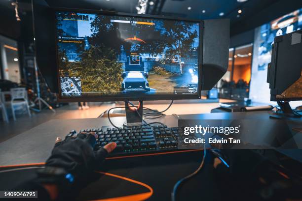 first-person-ansicht asiatischer esports-teamplayer beim schießen mit seinen teamkollegen in der grand final esport arena mit live-übertragung gegen ein anderes team - mouse pad stock-fotos und bilder