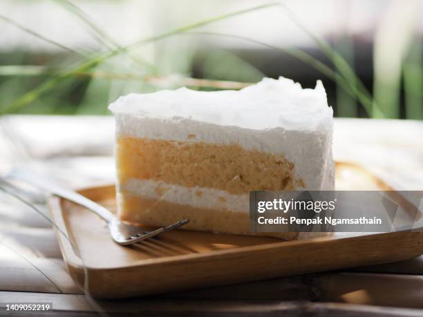 birthday cake piece coconut  with white whipped cream on a wooden plate - レイヤーケーキ ストックフォトと画像