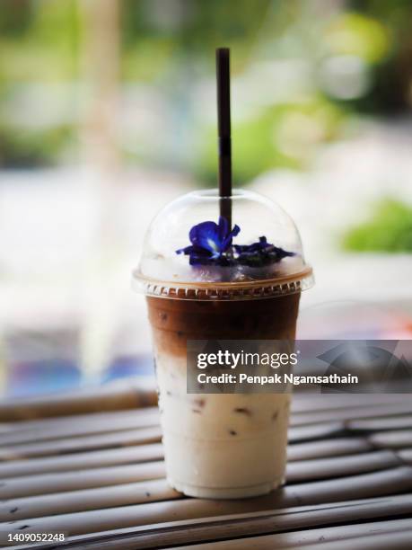 coffee latte close up view of ice cubes in cold brewed coffee in plastic cup put on bamboo desk blurred background, drink beverage - mokka eis stock-fotos und bilder