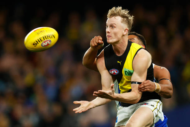 Noah Cumberland of the Tigers and Aiden Bonar of the Kangaroos contest the ball during the round 18 AFL match between the North Melbourne Kangaroos...