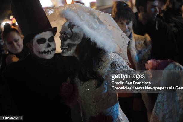 La Catrina and her spouse El Catrin walk along 24th street during a Day of the Dead celebration in the Mission district in San Francisco, Calif., on...