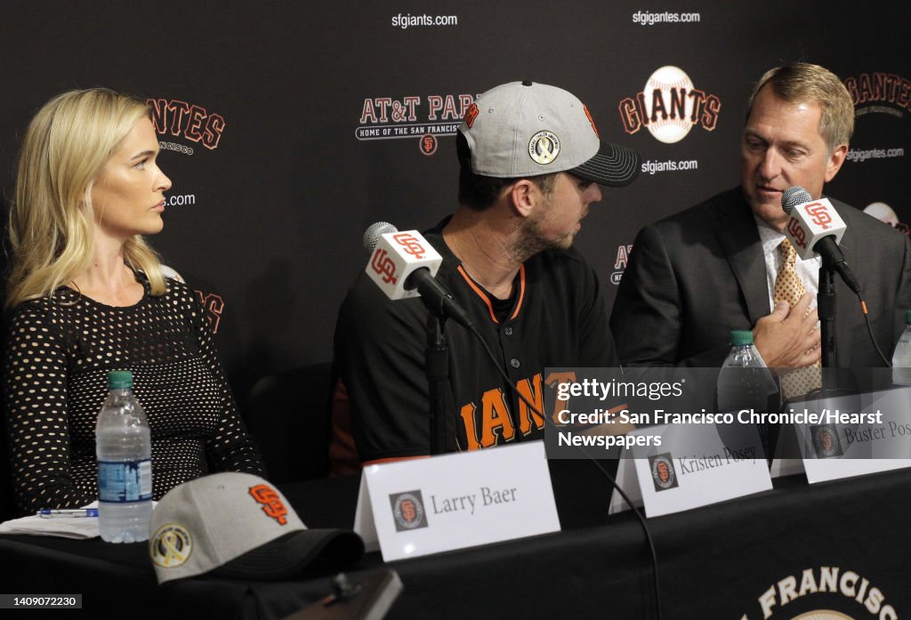 Kristen, left, and Buster Posey, center, listen as Christopher Koch, President and CEO of New Era, speaks during a press conference at AT&T Park in San Francisco, Calif., on Wednesday, April 20, 2016. Buster and Kristen Posey, along with the San Francisc
