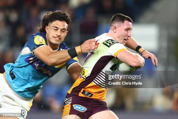 Tyson Gamble of the Broncos is tackled during the round 18 NRL match between the Gold Coast Titans and the Brisbane Broncos at Cbus Super Stadium, on...