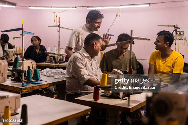 four men talking to each other at textile industry - textile factory stock pictures, royalty-free photos & images