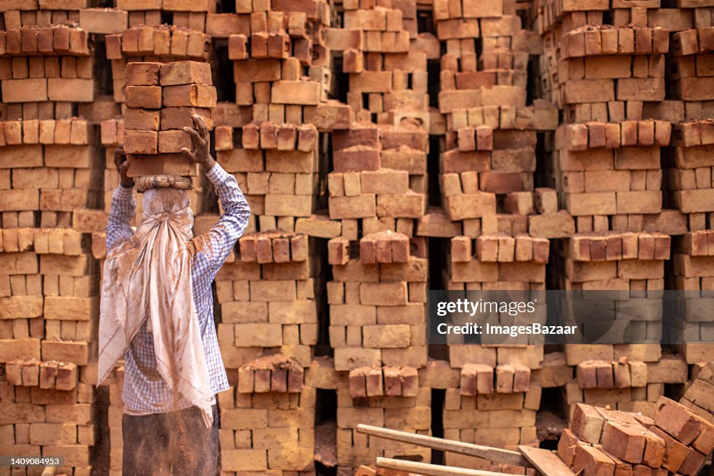 Mature Man Carrying Stack Of Bricks On His Head High-Res Stock Photo ...
