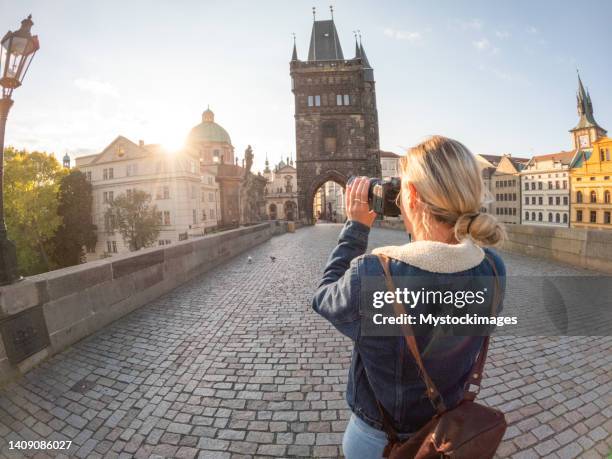 junge frau, die die stadt prag mit der kamera fotografiert - vltava river stock-fotos und bilder