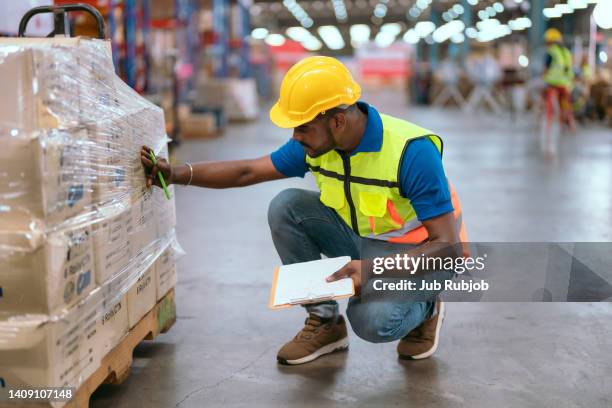 indian male worker checking goods in warehouse. - busy warehouse stock pictures, royalty-free photos & images