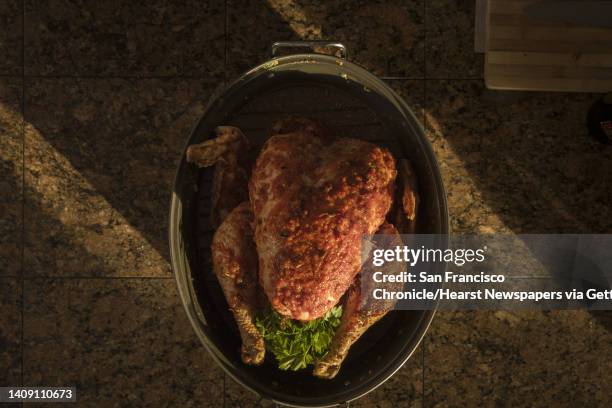 The sauced and seasoned turkey about to go in the oven as Jonnatan Leiva and his mom Anna Leiva prepare a family recipe of drunken turkey, or Pavo...
