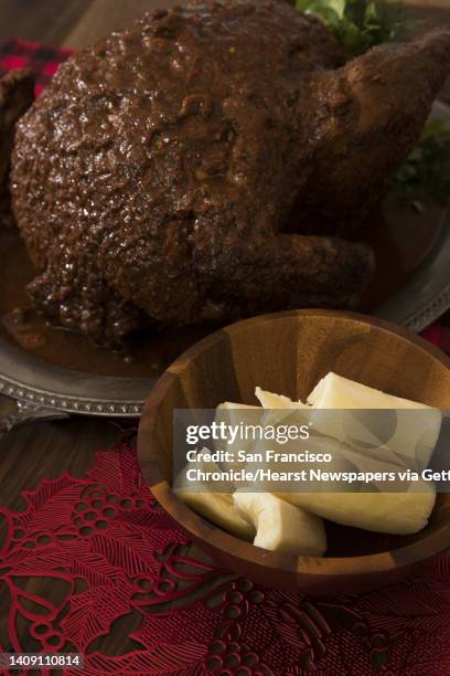 Steamed yucca next to a completed turkey as Jonnatan Leiva and his mom Anna Leiva prepare a family recipe of drunken turkey, or Pavo Borracho, in his...