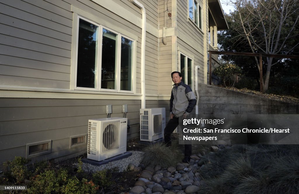 Wei-Tai Kwok shows the two compressors for his water heater and ductless heating/cooling units at his home that he completely converted to electric to stop using natural gas in Lafayette, Calif., on Monday, December 16, 2019. In January, new state require