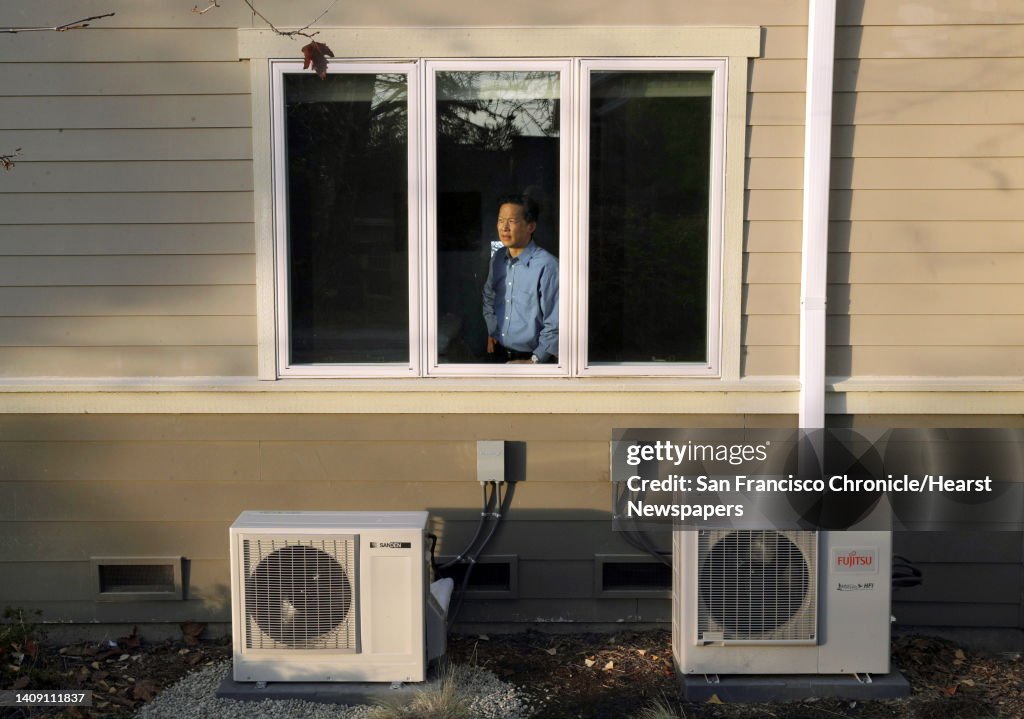 Wei-Tai Kwok with the two compressors for his water heater and ductless heating/cooling units at his home that he completely converted to electric to stop using natural gas in Lafayette, Calif., on Monday, December 16, 2019. In January, new state requirem