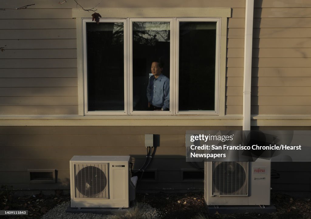 Wei-Tai Kwok with the two compressors for his water heater and ductless heating/cooling units at his home that he completely converted to electric to stop using natural gas in Lafayette, Calif., on Monday, December 16, 2019. In January, new state requirem