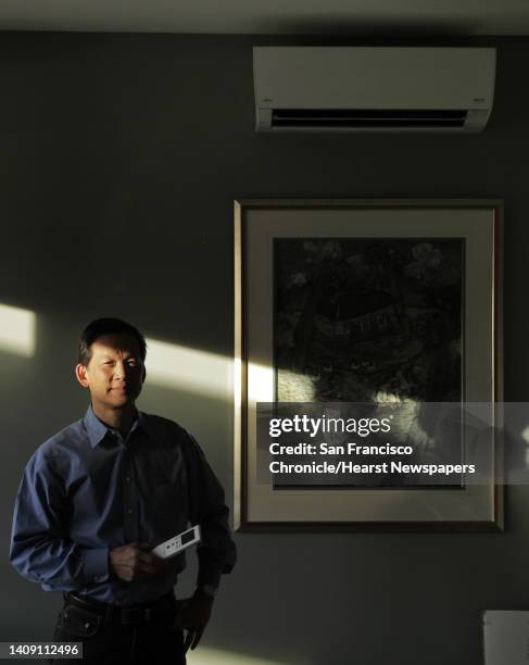 Wei-Tai Kwok next to the ductless heating/cooling system at his home that he completely converted to electric to stop using natural gas in Lafayette,...
