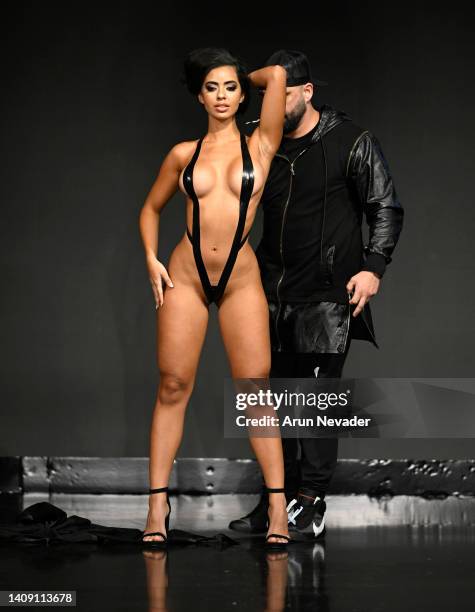 Designer Joel Alvarez and a model walk the runway wearing Black Tape Project at Miami Swim Week powered by Art Hearts Fashion at Faena Forum on July...
