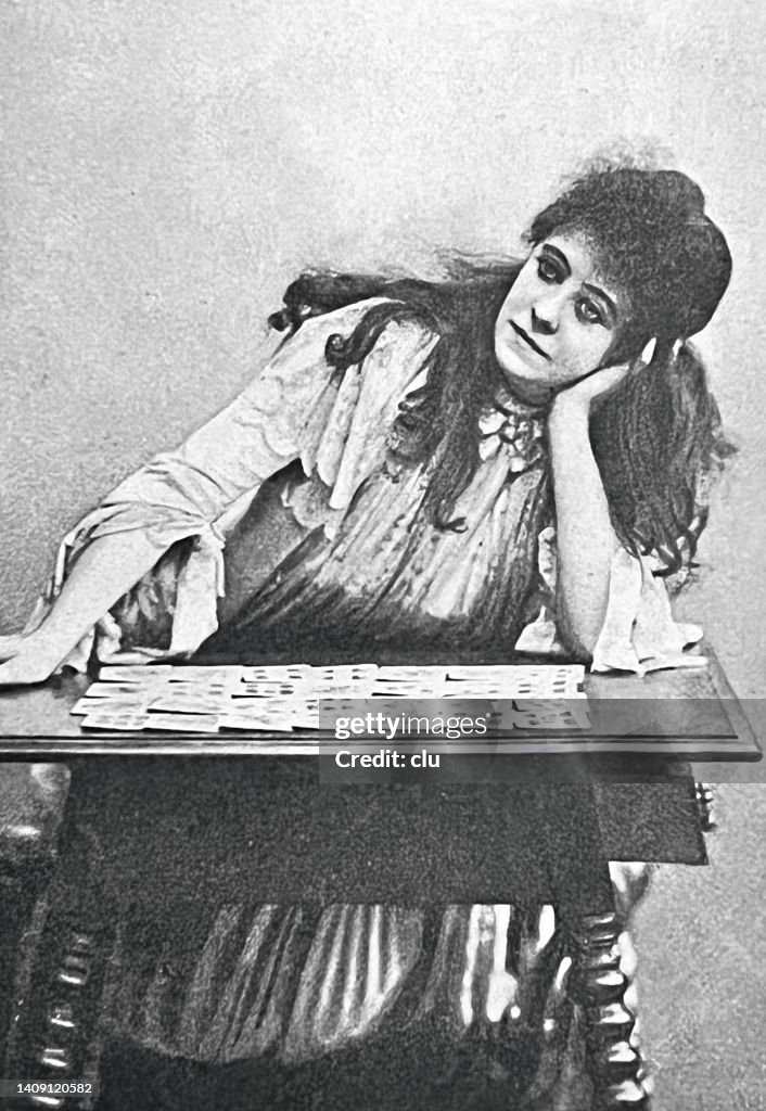 Adivina por cartas sentada en una mesa esperando la inspiración