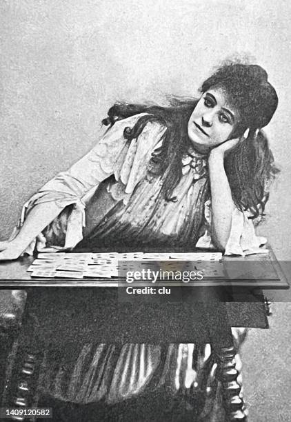 female fortune teller by cards sitting at a table waiting for the inspiration - tarot cards stock illustrations