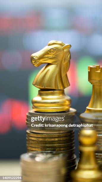 money with chess,gold unicorn chess and business chart ,business concept - cost management stockfoto's en -beelden