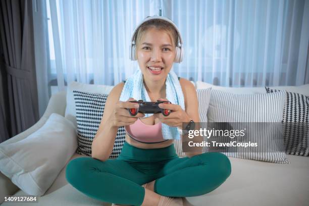 young woman playing console video games with wireless controller on green screen tv in living room. gamer girl relaxing at home doing online gaming on chroma key display. - gamepad stock pictures, royalty-free photos & images