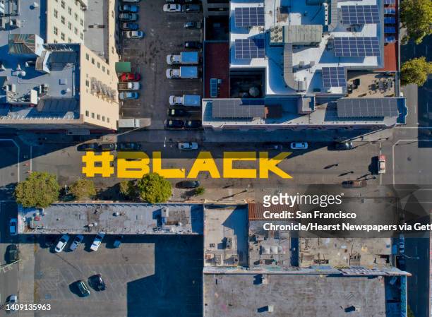 Mural of the words, “Black Lives Matter,” written in the street across three blocks of 15th Street, is shown in this composite of three aerial photos...
