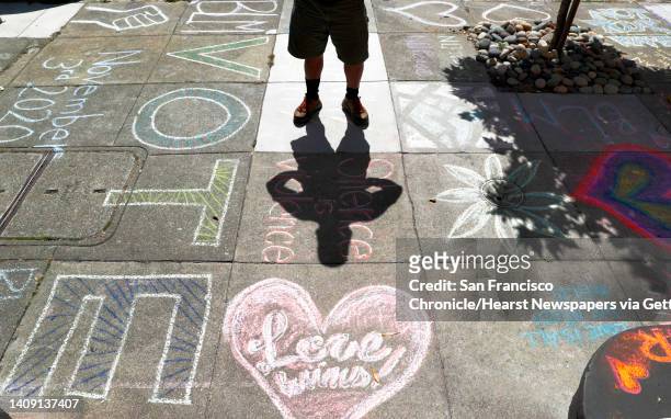 James Juanillo stands on on the sidewalk outside the home which has been covered in supportive chalk art in San Francisco, Calif., on Monday, June...