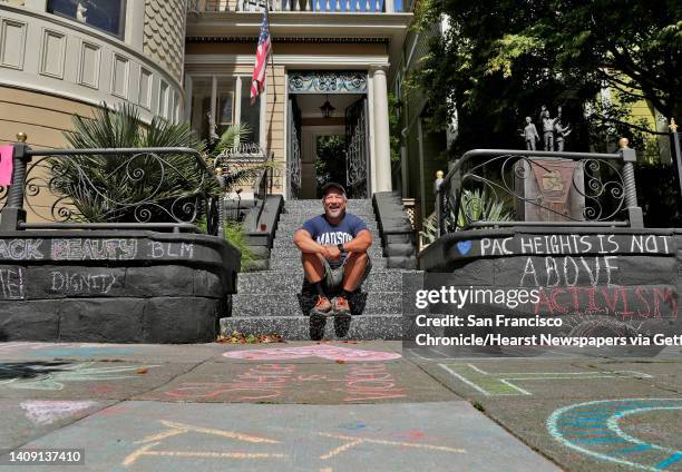 James Juanillo sits on the steps outside the home which has had the sidewalk covered in supportive chalk art in San Francisco, Calif., on Monday,...