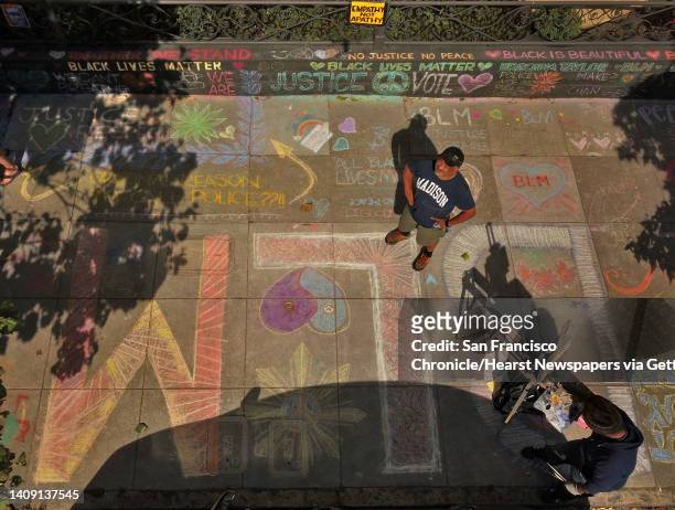 James Juanillo stands on the sidewalk outside the home which has been covered in supportive chalk art in San Francisco, Calif., on Monday, June 15,...
