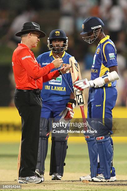 Umpire Bruce Oxenford and Farweez Maharoof of Sri Lanka looks at his bat after it broke during the third One Day International Final series match...