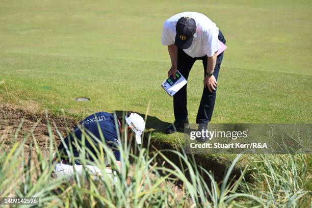 Filippo Celli of Italy receives a ruling from officials in a bunker on the 11th hole during Day Three of The 150th Open at St Andrews Old Course on...