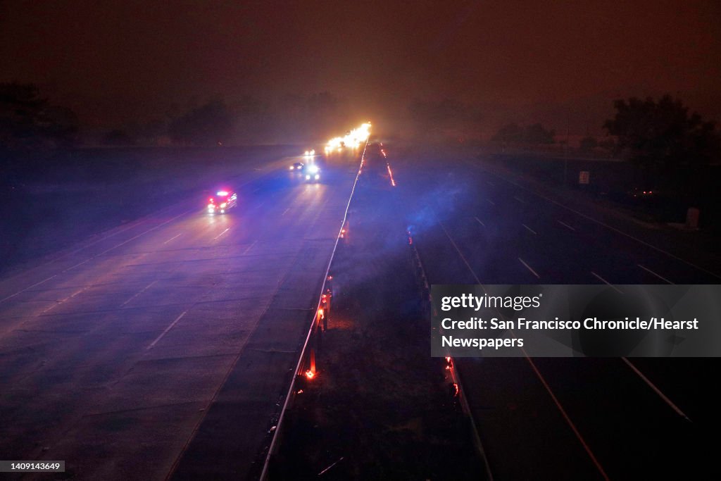 CHP officers escort drivers along westbound I-80 as the highway is reopened in Vacaville following a 5-hour closure due to the LNU Lightning Complex Fire burning into Vacaville, Calif., on Wednesday, August 19, 2020. The fire has consumed over 125,000 acr