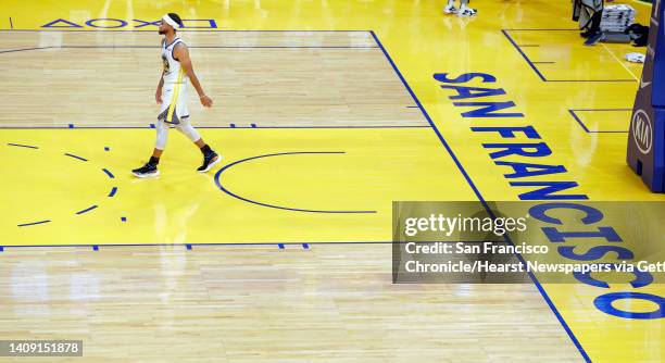 Stephen Curry walks back to center court for tip off during the first half as the Golden State Warriors played the Denver Nuggets in their first...