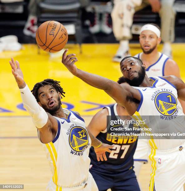 Marquese Chriss and Eric Paschall reach for a rebound during the first half as the Golden State Warriors played the Denver Nuggets in their first...