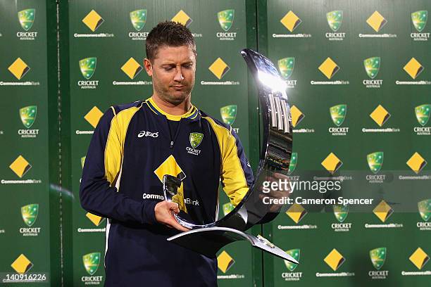 Injured Australian captain Michael Clarke inspects the trophy after Australia's victory in the third One Day International Final series match between...