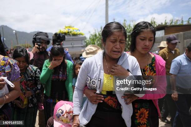 Family members accompany the coffin to the village cemetery during the funeral of Pascual Melvin Guachiac Sipac on July 16, 2022 in Nahualá,...