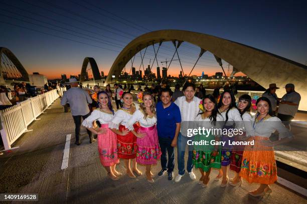 At night with the downtown skyline in the background Congressman Jimmy Gomez and City Councilman Kevin de León pose with the all woman mariachi band...