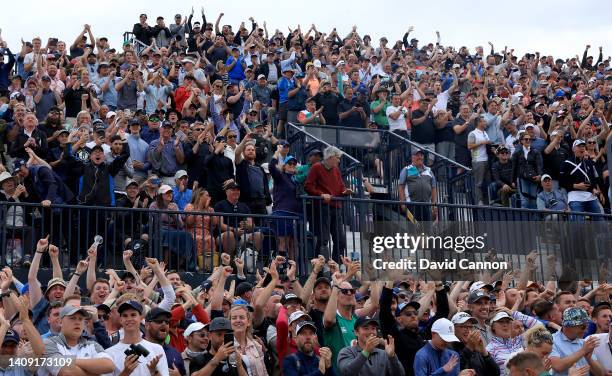 Spectators in the grandstand beside the 11th tee and 10th green react joyously as Rory McIlroy holed his second shot from a fairway bunker on the...