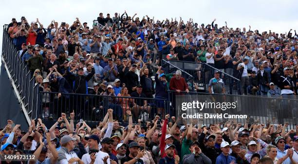 Spectators in the grandstand beside the 11th tee and 10th green react joyously as Rory McIlroy holed his second shot from a fairway bunker on the...