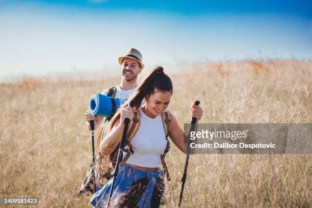 couple walking on grassy hill - caucasian mountain climber man stock pictures, royalty-free photos & images