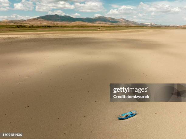 aerial view of a fishing boat on a drought dry lakebed. - dry land stock pictures, royalty-free photos & images